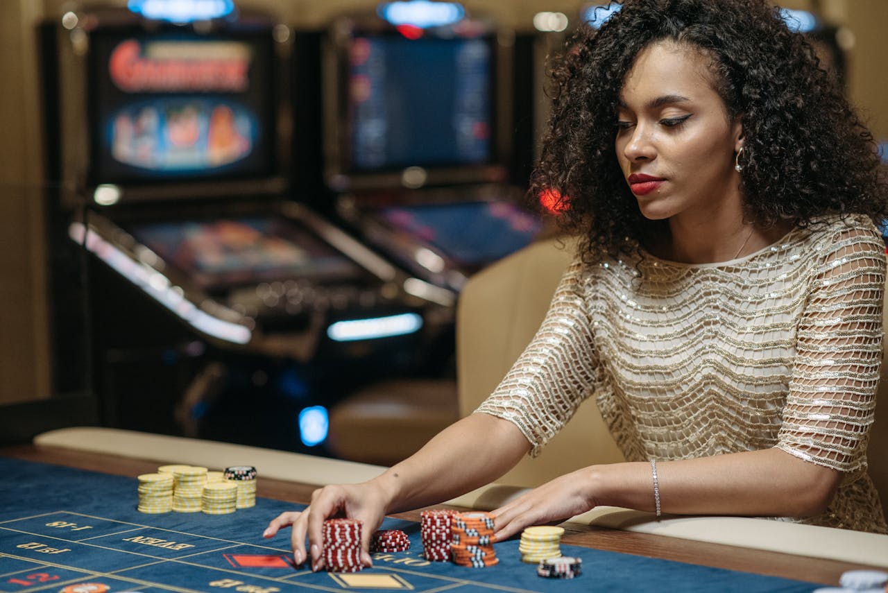 Elegant African American woman betting at casino gaming table with chips.